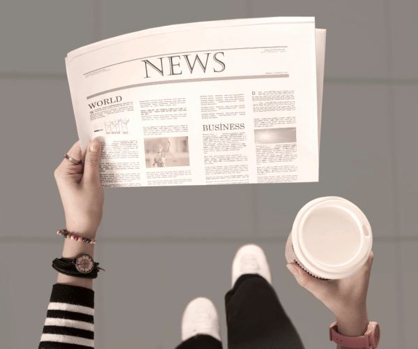 women_walking_with_newspaper_and_coffee